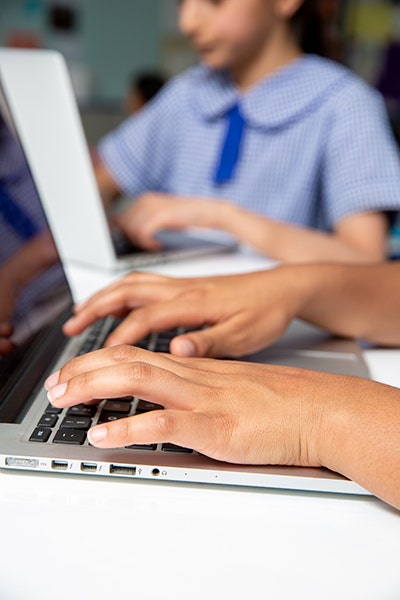 Photo of hands typing on a laptop